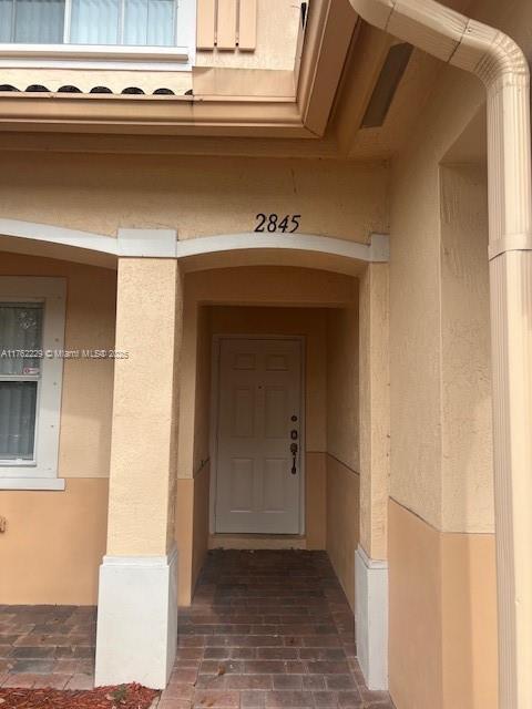 entrance to property with stucco siding