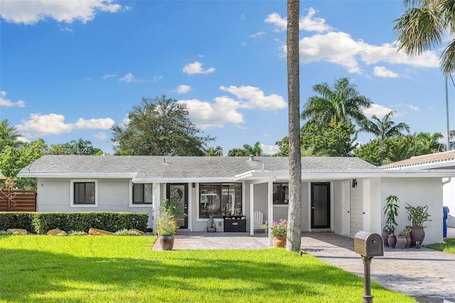 rear view of property featuring a yard and stucco siding