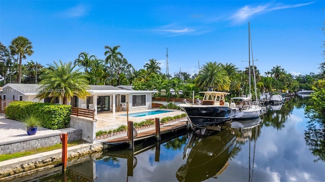dock area featuring a water view, an outdoor pool, and a patio area