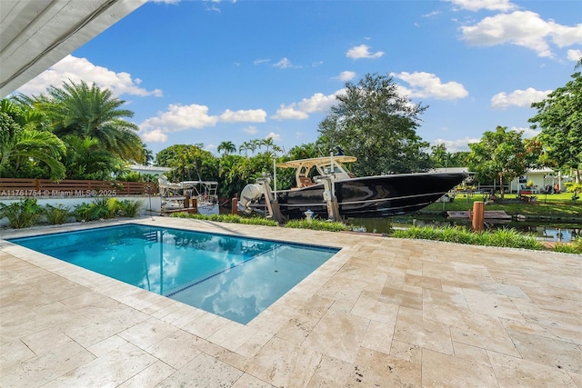 pool with a patio area and fence