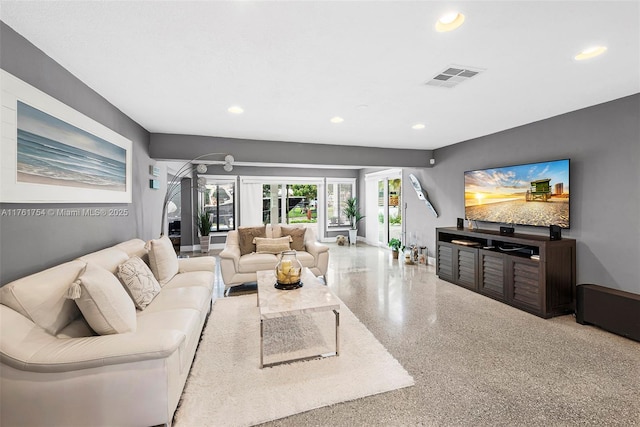 living room with recessed lighting, visible vents, and speckled floor