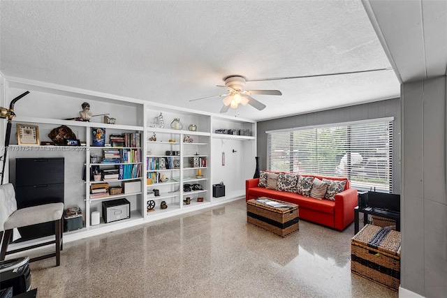 living area featuring a textured ceiling, ceiling fan, built in shelves, and speckled floor