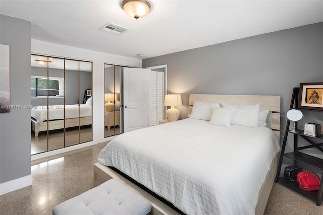 bedroom with baseboards, multiple closets, visible vents, and speckled floor