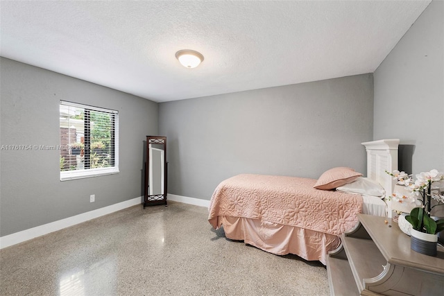 bedroom featuring baseboards, a textured ceiling, and speckled floor