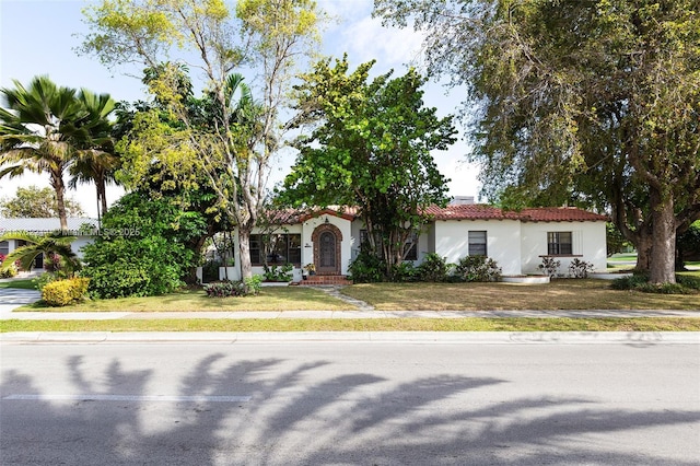 mediterranean / spanish-style home featuring a front lawn and stucco siding