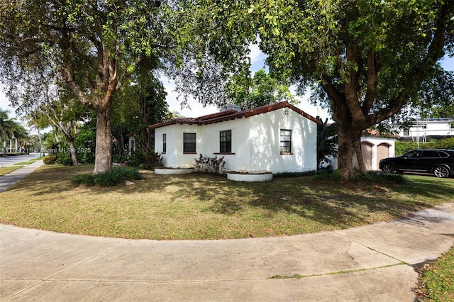 view of front of home featuring stucco siding and a front lawn