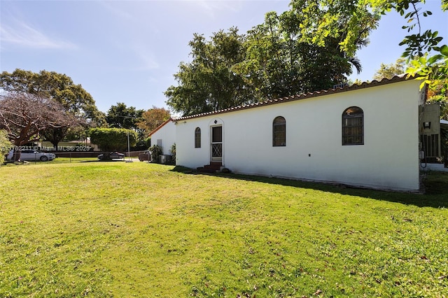 back of property featuring a yard and stucco siding