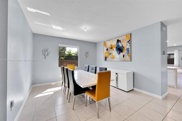 dining room with light tile patterned floors and baseboards