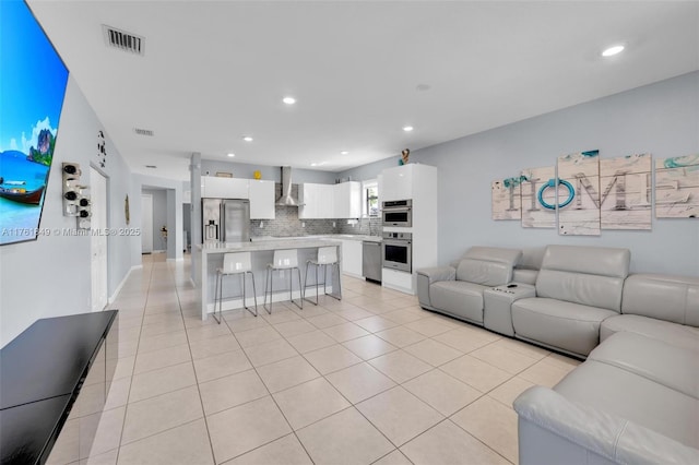 living room featuring light tile patterned flooring, recessed lighting, and visible vents