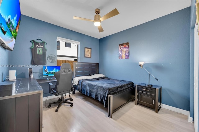 bedroom with ceiling fan, baseboards, and light wood-style floors