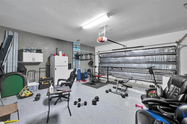 workout area with a textured ceiling and a garage