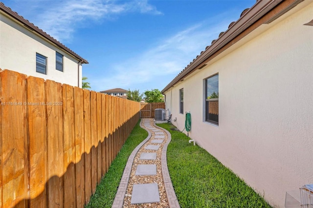 view of yard featuring central AC unit and fence