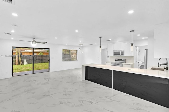 kitchen with visible vents, a sink, stainless steel appliances, white cabinets, and modern cabinets