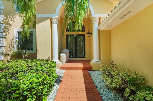 view of exterior entry featuring stucco siding and french doors