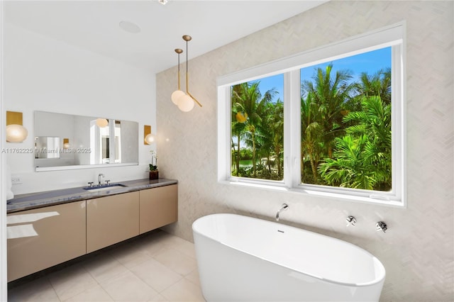 full bath with tile patterned floors, a soaking tub, and vanity