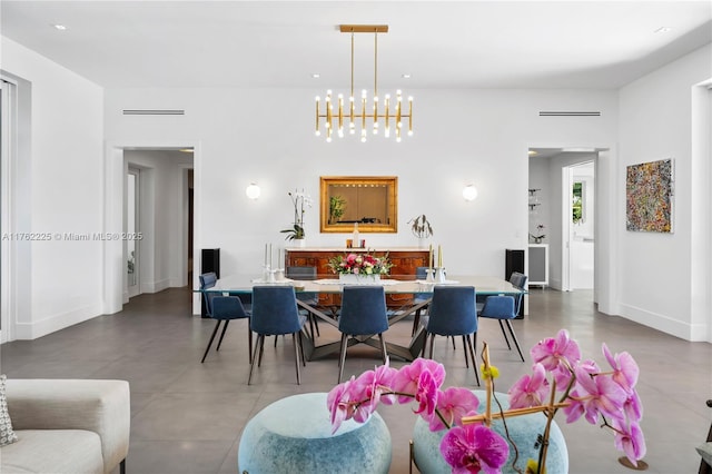 dining room featuring an inviting chandelier and baseboards