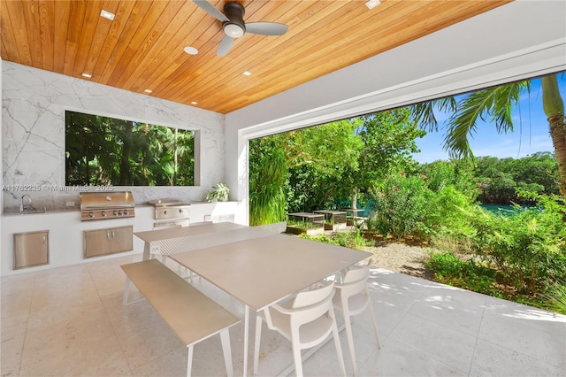 view of patio featuring a ceiling fan, an outdoor kitchen, outdoor dining area, a sink, and grilling area