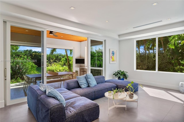 living room featuring a wealth of natural light, visible vents, tile patterned flooring, and a ceiling fan