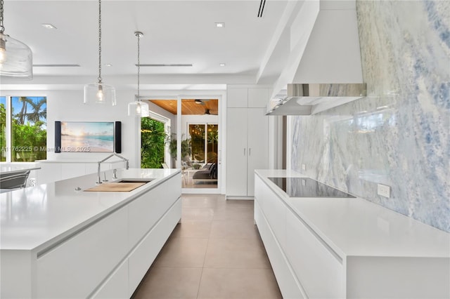 kitchen with wall chimney range hood, a sink, white cabinetry, black electric stovetop, and modern cabinets