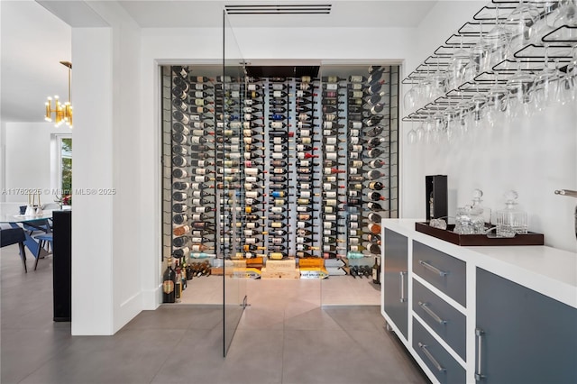 wine area with tile patterned floors and a notable chandelier