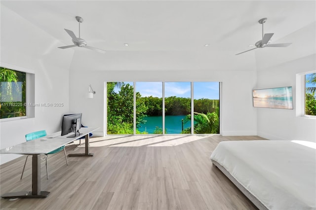 bedroom featuring baseboards, lofted ceiling, ceiling fan, and light wood finished floors