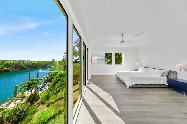 bedroom featuring ceiling fan, a water view, and wood finished floors