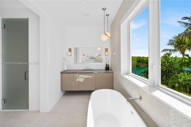 full bath with vanity, a soaking tub, and tile patterned floors