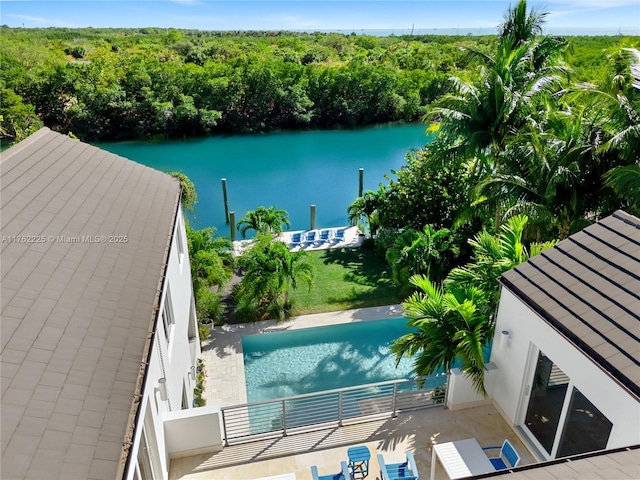 exterior space featuring a wooded view and a water view