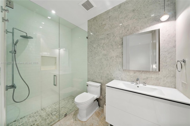 full bathroom featuring vanity, visible vents, a stall shower, tile walls, and toilet