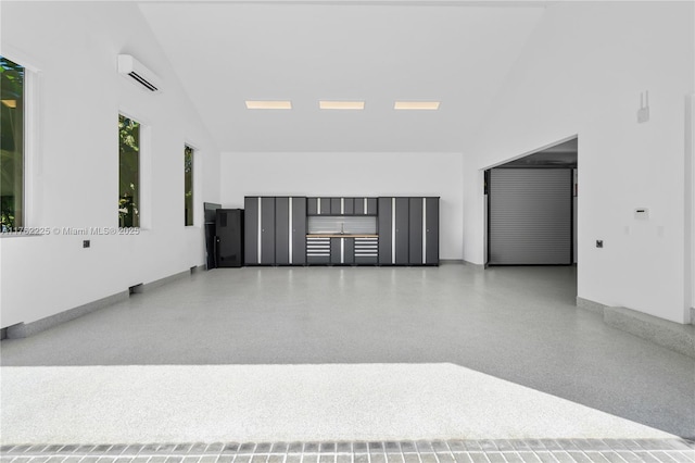 empty room featuring light speckled floor, high vaulted ceiling, and a wall mounted AC