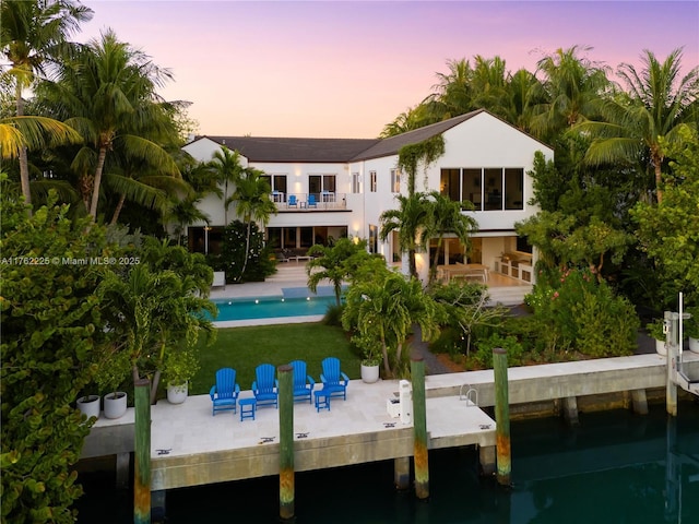 rear view of house with an outdoor pool, a balcony, and a patio area