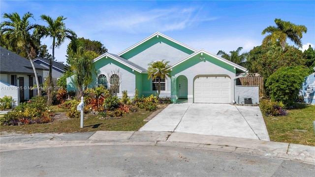 ranch-style house with concrete driveway, fence, a garage, and stucco siding