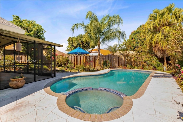 view of pool with fence, a pool with connected hot tub, and a patio area