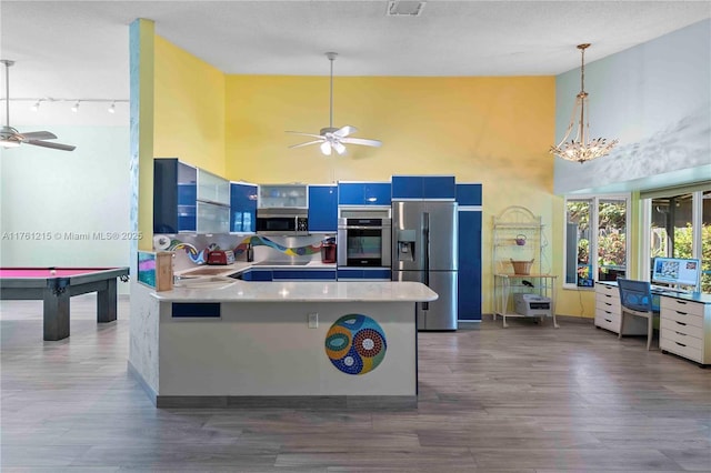 kitchen with blue cabinetry, ceiling fan, appliances with stainless steel finishes, dark wood-style floors, and a sink