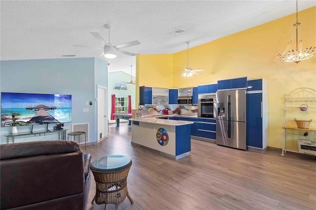 kitchen featuring a peninsula, blue cabinetry, visible vents, and stainless steel appliances