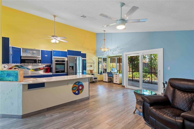 kitchen featuring visible vents, light countertops, appliances with stainless steel finishes, blue cabinets, and open floor plan