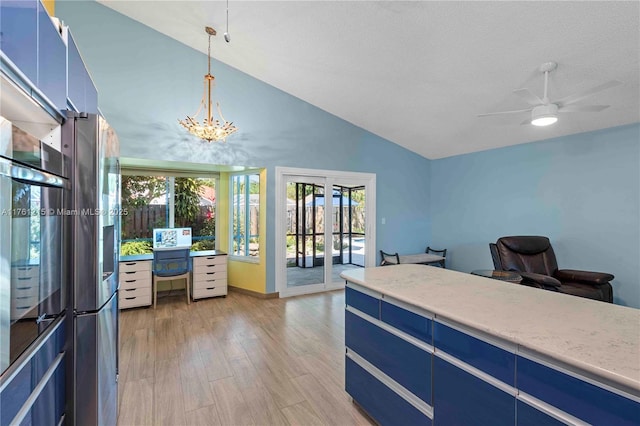 office space with ceiling fan with notable chandelier, a healthy amount of sunlight, light wood-type flooring, and french doors