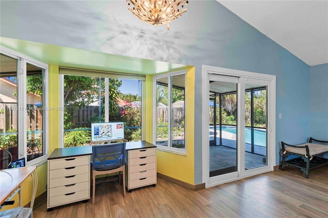 office featuring a healthy amount of sunlight, baseboards, lofted ceiling, and wood finished floors