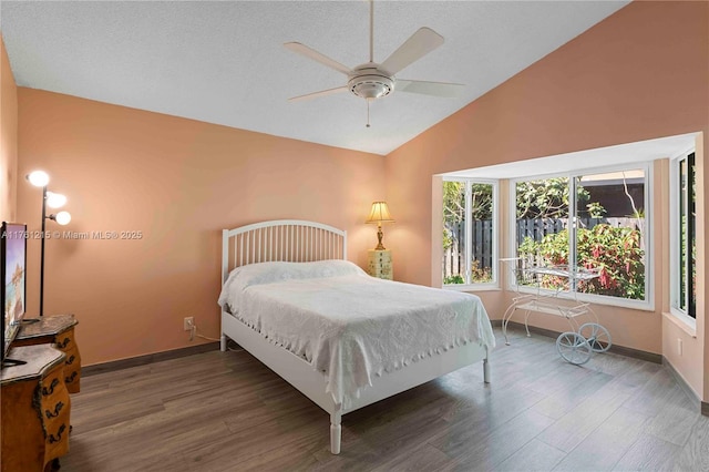 bedroom featuring a ceiling fan, vaulted ceiling, wood finished floors, and baseboards