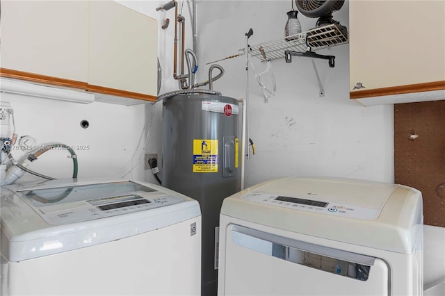 laundry area featuring water heater, washer and dryer, and cabinet space