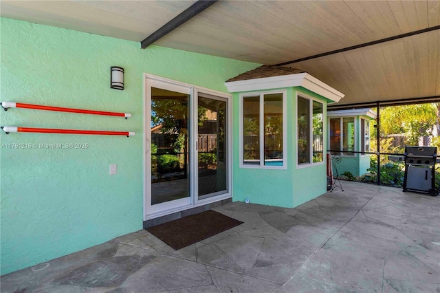 entrance to property with stucco siding and a patio area