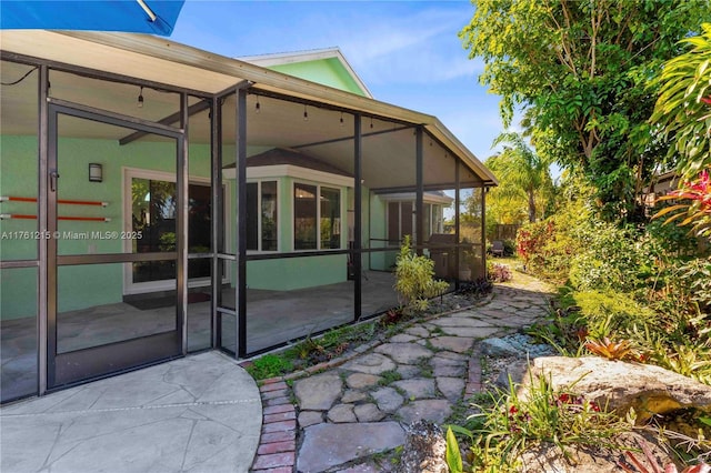 back of property with a patio area and a sunroom