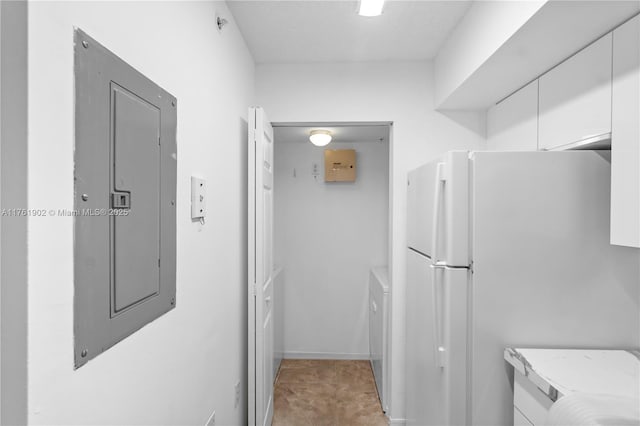 kitchen with electric panel, white cabinetry, light countertops, and freestanding refrigerator