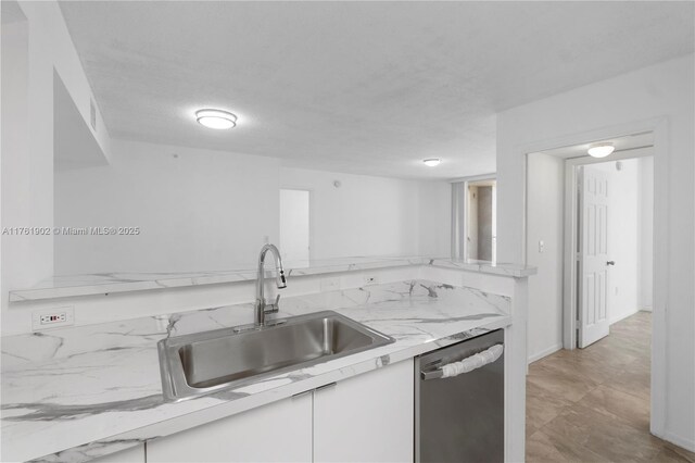 kitchen featuring a sink, white cabinetry, baseboards, and stainless steel dishwasher