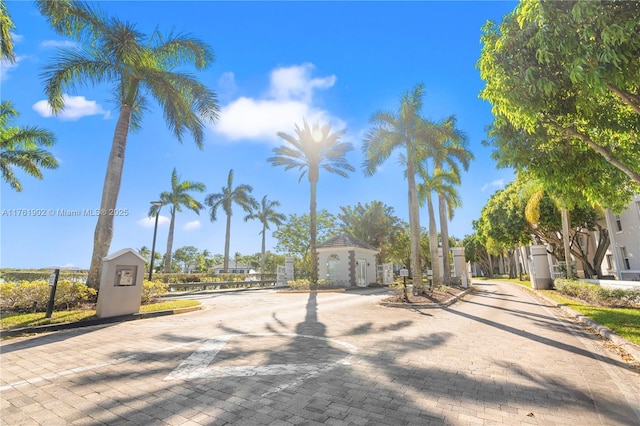 view of street with a gated entry and curbs