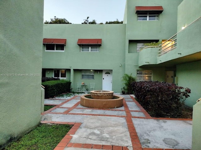 exterior space featuring stucco siding and a fire pit