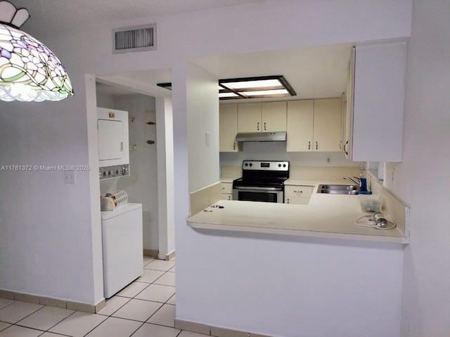 kitchen featuring visible vents, a sink, under cabinet range hood, light countertops, and stainless steel electric range oven