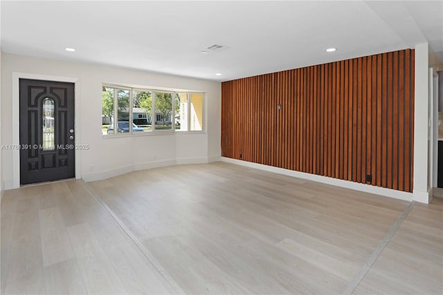 interior space with recessed lighting, light wood-type flooring, and wooden walls