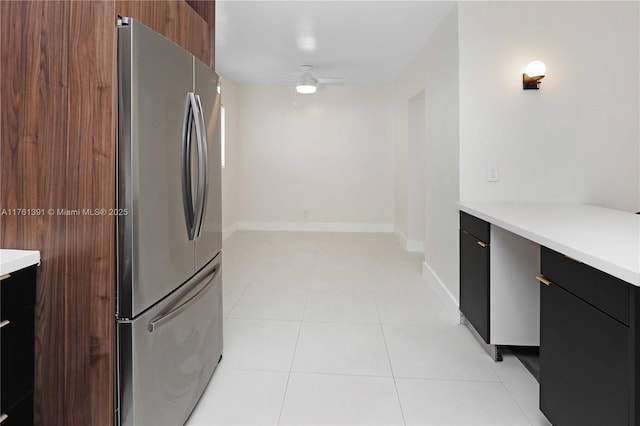 kitchen with modern cabinets, freestanding refrigerator, light countertops, light tile patterned floors, and ceiling fan