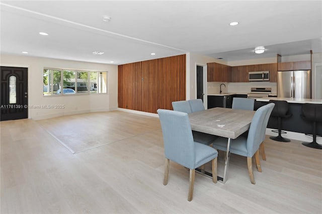 dining space with recessed lighting, baseboards, and light wood-style flooring